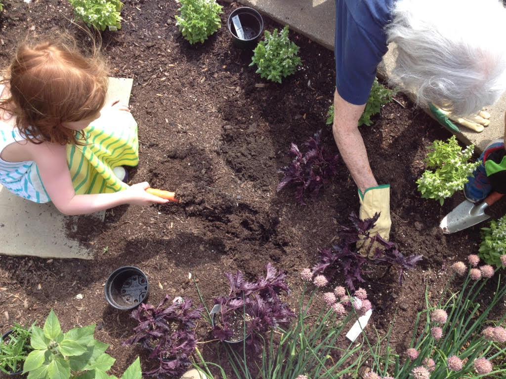 A girl and a woman planting herbs